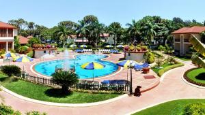 a pool at a resort with umbrellas at Radhika Beach Resort & Spa Diu in Nagwa