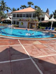 a group of people swimming in a swimming pool at Radhika Beach Resort & Spa Diu in Nagwa