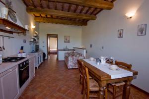 - une cuisine avec une table, des chaises et un comptoir dans l'établissement PODERE LE VOLPAIE, à Montecatini Val di Cecina