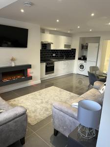 a living room with a couch and a fireplace at Beautiful 4 Berth Seaside Apartment On Ground Floor In Hemsby, Ref 99010fh in Great Yarmouth