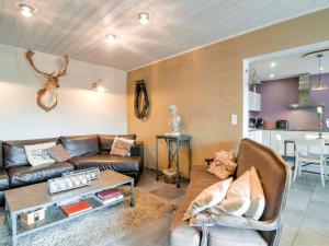 ein Wohnzimmer mit einem Sofa und einem Tisch in der Unterkunft Great holiday home in Bastogne with sauna in Le Parque