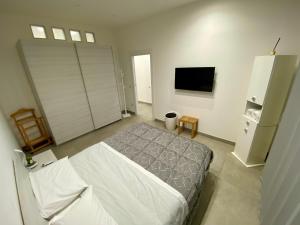 a bedroom with a bed and a flat screen tv at Appartamento Casa Crispino Piano terra per 3 persone in Frattaminore