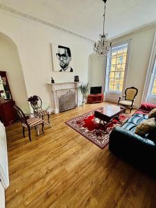 a living room with a couch and a fireplace at Charming Apartment in the Heart of Bath in Bath