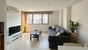 a living room with a couch and a tv at M3 Céntrico y con Terraza in Terrassa