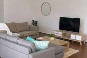 a living room with a couch and a flat screen tv at Vitamin Sea by the Beach by Ready Set Stay in Cowes