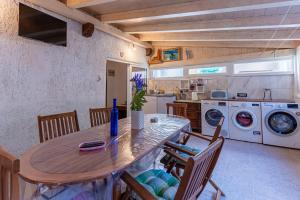 a kitchen with a table and chairs and a washing machine at Guesthouse Romana in Cres