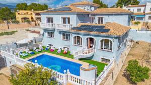 eine Luftaufnahme eines Hauses mit Swimmingpool in der Unterkunft Villa Flora - Plusholidays in Calpe