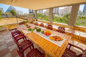 einen Holztisch mit Essen auf dem Balkon in der Unterkunft Villa Flora - Plusholidays in Calpe