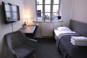 a room with a desk and a bed and a chair at Hotel Aarhus City Apartments in Aarhus