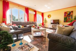 ein Wohnzimmer mit zwei Sofas und einem Fernseher in der Unterkunft Villa Flora - Plusholidays in Calpe