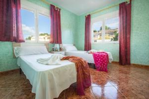 ein Schlafzimmer mit zwei Betten und zwei Fenstern in der Unterkunft Villa Flora - Plusholidays in Calpe + 51 Fotos