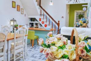 Cette chambre comprend une table avec des fleurs. dans l'établissement The Wind B&B, à Budai