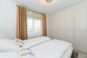 ヴィーク・アウフ・フェールにあるHaus Bi de Wyk D6Bのベッドルーム1室(白いベッド2台、窓付)
