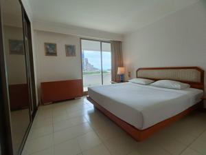 a bedroom with a large bed and a large window at The Monaco Residence in Pattaya South +76 photos