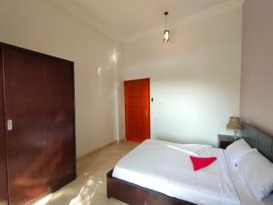 Un dormitorio con una cama blanca con una estrella roja. en Cleopatra House, en Luxor