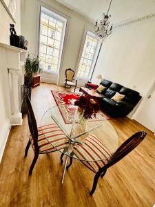 a living room with a glass table and a couch at Charming Apartment in the Heart of Bath in Bath