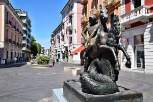 Una estatua de una chica y una serpiente en una calle en Isonzo Home, en Cosenza