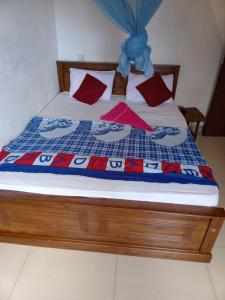 Una cama con una manta azul y roja. en Dreamscape home stay en Kandy