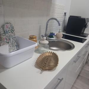 a kitchen counter with a sink and a plate and dishes at Apartmán s výhľadom na Spišský Hrad in Studenec