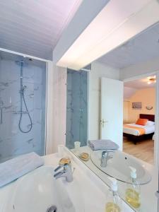 a bathroom with a sink and a shower and a mirror at Au calme à 10mn des baies de Douarnenez et Audierne avec cuisine à disposition in Mahalon