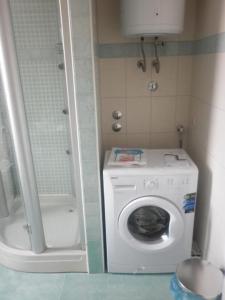 a small bathroom with a washing machine and a shower at Studio mit Balkon für zwei Personen - b56476 in Split