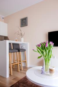 a living room with a table with a vase of flowers at Apartament Bimba & Free Parking in Poznań