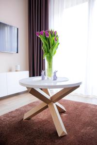 a table with a vase of flowers on top of it at Apartament Bimba - Free Parking in Poznań