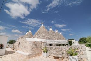 セルヴァ・ディ・ファザーノにあるNina Trulli Resortの青空を背景にした大きな石造りの建物
