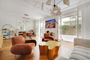 a living room with a couch and chairs and a table at JO - Appartement porte maillot Paris 16 - 4P in Paris