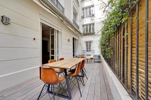 a wooden table and chairs sitting on a deck at JO - Appartement porte maillot Paris 16 - 4P in Paris