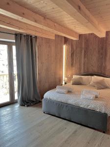 - une chambre avec un lit et un mur en bois dans l'établissement Courmayeur Superior Suite by SupaStays, à Courmayeur