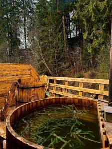 uma banheira de madeira cheia de água ao lado de uma cerca de madeira em Naciku SPA Hotel em Bukovel