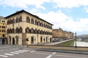 a building on a street next to a river at Leone Blu Suites | UNA Esperienze in Florence