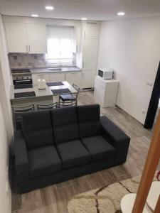 a living room with a black couch in a kitchen at Casa de São Miguel in Mirandela