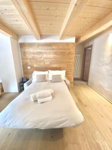 - une chambre avec un lit blanc et 2 serviettes dans l'établissement Courmayeur Superior Suite by SupaStays, à Courmayeur