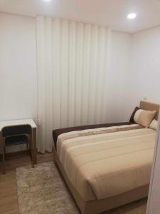 a bedroom with a bed and a chair in it at Casa de São Miguel in Mirandela