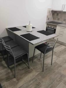a kitchen with a counter with chairs and a table at Casa de São Miguel in Mirandela +6 photos