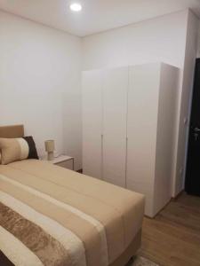 1 dormitorio con 1 cama y armario blanco en Casa de São Miguel, en Mirandela