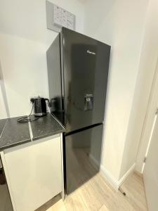 um frigorífico de aço inoxidável numa cozinha com um balcão em London Oasis Retreat - Central 2BR Apartment park em Hendon