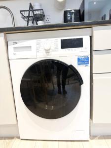 a washing machine with its door open in a kitchen at Inviting 2-Bed Apartment in London free parking in Hendon