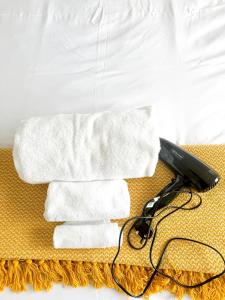 um secador de cabelo preto sentado ao lado de uma pilha de toalhas em London Oasis Retreat - Central 2BR Apartment park em Hendon