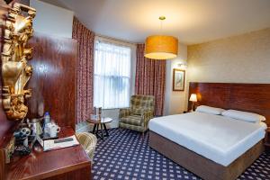 a hotel room with a bed and a chair at The Foley Arms Hotel Wetherspoon in Great Malvern