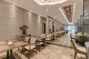 UrCove by Hyatt Shanghai Pudong East في شانغهاي: مطعم فيه طاولات وكراسي في الغرفة