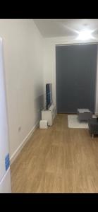 a living room with a tv and a wooden floor at Spacious apartment in Barking