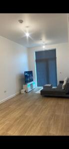 a large living room with a bed and a television at Spacious apartment in Barking