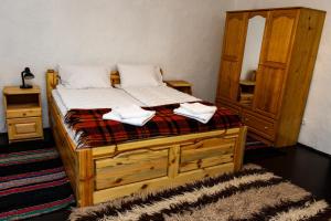 a bedroom with a wooden bed with towels on it at СТАРАТА КЪЩА in Sovolyano