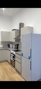 a kitchen with a white refrigerator and a stove at Spacious apartment in Barking