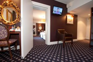 ein Hotelzimmer mit einem Spiegel und einem Schlafzimmer in der Unterkunft The Foley Arms Hotel Wetherspoon in Great Malvern