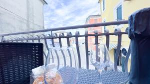 a table with two wine glasses on a balcony at Alicetta Apartment by Ca-Sa Check in Chioggia
