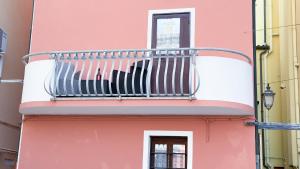 a balcony on the side of a pink building at Alicetta Apartment by Ca-Sa Check in Chioggia